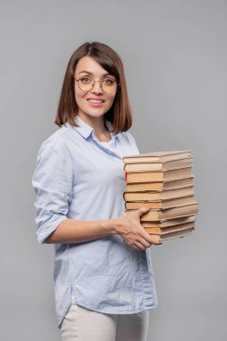 Edebiyat genç başarılı öğretmen veya ders için gidiyor kitap yığını ile üniversite öğrencisi