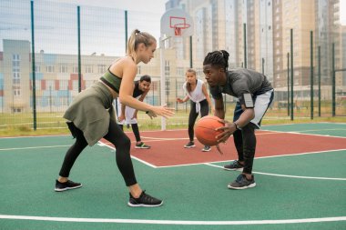 Oyun sırasında karşılıklı sahada duran top ve sarışın sporcu ile genç Afrikalı oyuncu