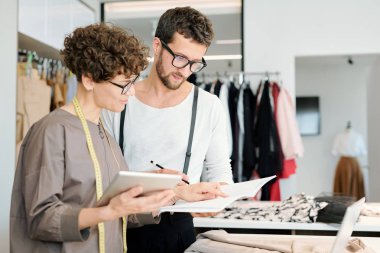 İki genç yaratıcı moda tasarımcıları mevsimsel koleksiyon için yeni skeç bakıyor ve tartışıyor