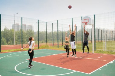 Yaz günü basketbol sahasında çalışan genç kültürlerarası arkadaş veya öğrencilerden oluşan ekip