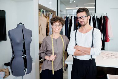 Kendi stüdyosunda çalışırken manken tarafından ayakta giyim iki mutlu genç yaratıcı tasarımcılar