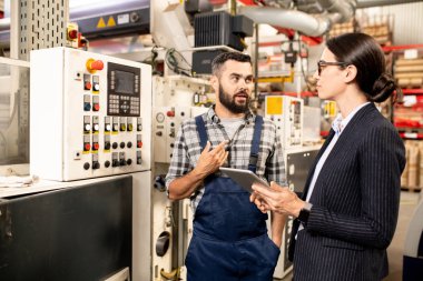 Genç kendinden emin polimer işleme fabrikası mühendisi kadın iş ortağı bir şey açıklayan