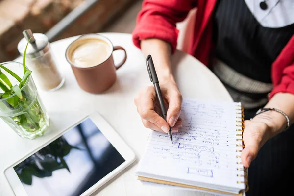 Jovem Mulher Escrevendo Notas Trabalho Caderno Enquanto Sentado Mesa Café — Fotografia de Stock