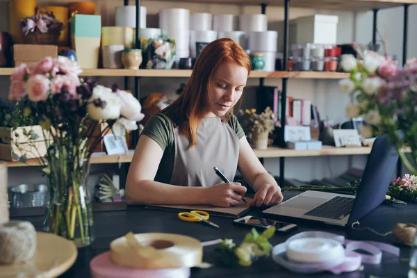 Busy Young Woman Red Hair Standing Counter Making Notes Sketchpad — Stock Photo, Image