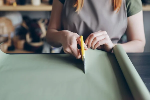 Close Unrecognizable Woman Apron Standing Counter Cutting Green Wrapping Paper — Stock Photo, Image