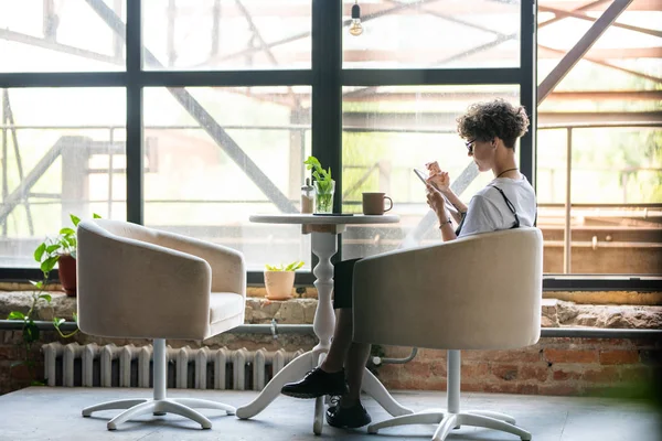 Joven Hembra Sentada Sillón Por Ventana Estudio Relajándose Bebiendo Usando — Foto de Stock