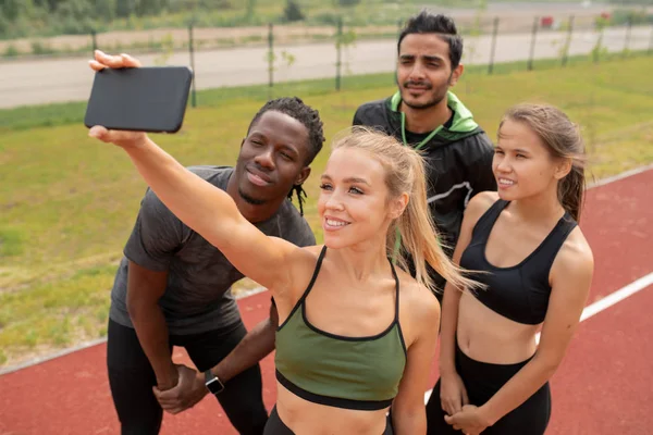 Menina Loira Bonita Activewear Fazendo Selfie Com Seus Amigos Perto — Fotografia de Stock