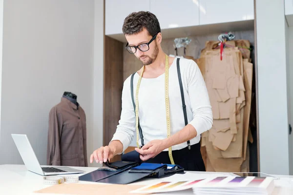 Joven Sastre Ropa Casual Mirando Través Muestras Textiles Mientras Trabaja — Foto de Stock