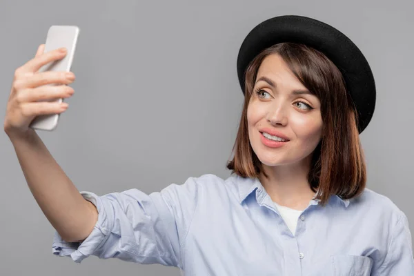 Joven Hermosa Mujer Mirando Cámara Teléfono Inteligente Mientras Hace Selfie —  Fotos de Stock