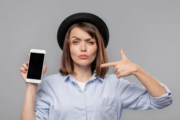 Brunette Meisje Hoed Shirt Toont Melding Smartphone Terwijl Erop Wijst — Stockfoto