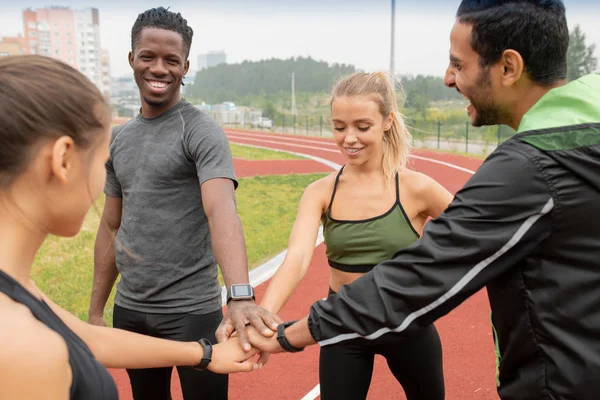 Quatre Jeunes Athlètes Heureux Faisant Pile Mains Tout Tenant Debout — Photo