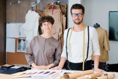 Yeni moda koleksiyonu iki genç kendinden emin tasarımcılar atölye içinde masa başı her zamanki işlerini yapıyor