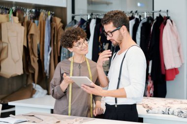 Genç giyim tasarımcıları touchpad kendi moda koleksiyonu için yeni dijital skeçler ayrıntılarını tartışıyor