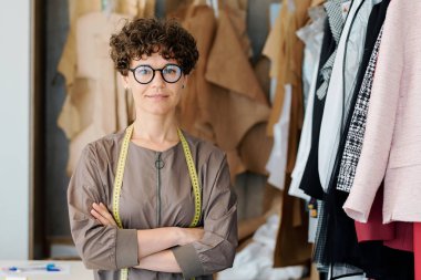 Onun moda stüdyosu veya butik ayakta gözlük genç zarif kadın size bakıyor