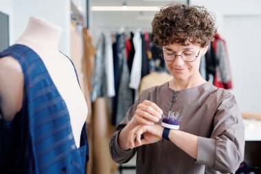 Atölyede yeni elbise üzerinde çalışırken bileğine pincushion pin alarak genç terzi