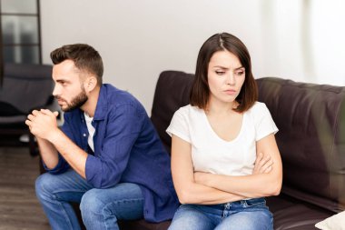 Üzgün sinirli genç çift kavga oturma odasında kanepede oturan ve sorunlarını düşünme olmak