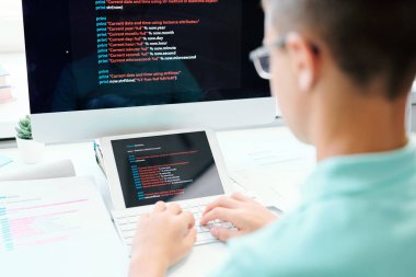 Bilgisayar tuş takımı düğmelerine basıp veri girerken işyeri başında oturan genç erkek