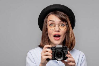 Meraklı çekim yaparken şaşkınlıkla size bakarak kamera ile şaşırttı genç kadın