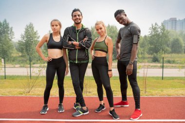 Kentsel ortamda açık stadyumda size bakarak activewear mutlu genç kültürlerarası arkadaşlar Satır