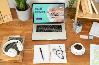 Modern tasarımcı, öğrenci veya iş adamının işyeri olan masanın üzerindeki dizüstü bilgisayar ve diğer ofis malzemeleri ve nesneleri