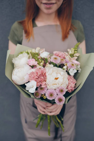 Blízko Kreativního Květinářství Zástěře Krásnou Kytici Peoniemi Zabalenou Zeleného Papíru — Stock fotografie