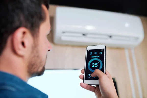 Joven Con Smartphone Usando Aplicación Inteligente Para Ajustar Soportar Temperatura — Foto de Stock