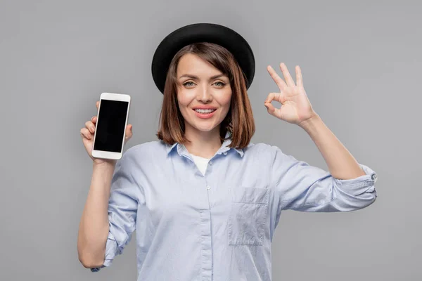 Молодая Случайная Женщина Показывает Нормальный Жест Промо Сезонной Продажи Смартфоне — стоковое фото