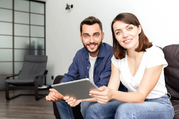Portrait Positive Beautiful Young Couple Sitting Leather Sofa Home Using — Stock Photo, Image