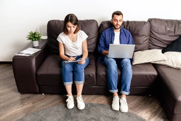 Allvarligt Ungt Par Koncentrerade Sig Online Kommunikation Sitter Soffan Vardagsrummet — Stockfoto