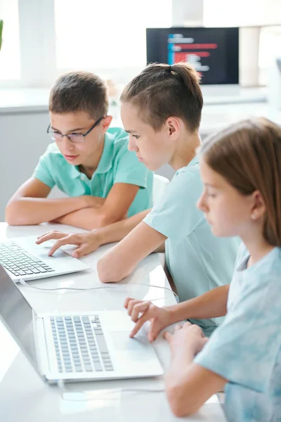 Fila Escolares Bonitos Sérios Casualwear Sentado Mesa Frente Laptops Enquanto — Fotografia de Stock