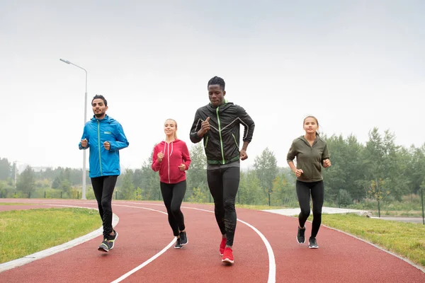 参加体育场马拉松或短跑比赛的青年跨文化运动员和女运动员团体 — 图库照片