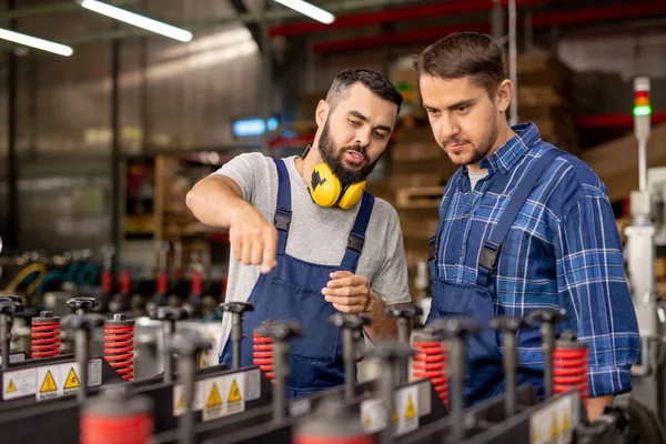 Jovem Estagiário Olhando Para Equipamentos Industriais Enquanto Gerente Confiante Explicando — Fotografia de Stock