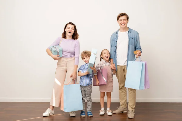 Lachen Jonge Ouders Met Paperbags Geschenkdozen Hun Vrolijke Zoon Dochter — Stockfoto