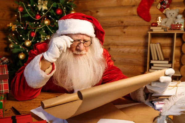 Papai Noel Óculos Lendo Atentamente Grande Carta Desejos Natal Enquanto — Fotografia de Stock