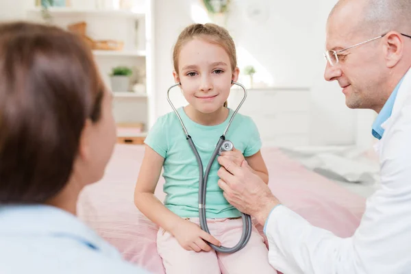 Niña Feliz Con Estetoscopio Escuchando Latido Del Corazón Mientras Está — Foto de Stock