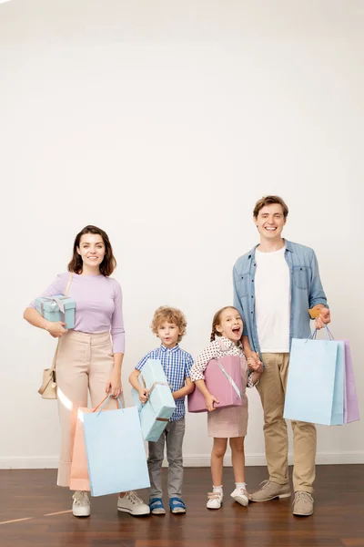 Gelukkig Jonge Ouders Met Paperbags Twee Kleine Kinderen Met Geschenkdozen — Stockfoto