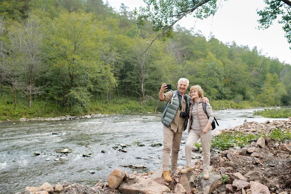 Två Glada Mogna Vandrare Med Ryggsäckar Gör Selfie Flodstranden När — Stockfoto