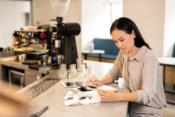 Joven Asiática Morena Contable Sentado Mesa Cafetería Mientras Usa Calculadora — Foto de Stock