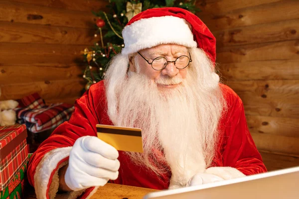 Mobile Santa Com Cartão Plástico Olhando Para Tela Laptop Enquanto — Fotografia de Stock