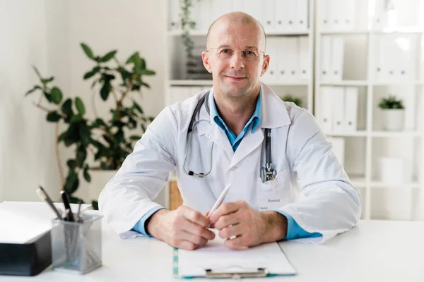 Jovem Clínico Sucesso Óculos Whitecoat Sentado Mesa Consultório Médico Frente — Fotografia de Stock