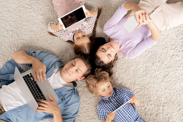 Top View Young Family Four Lying Floor Scrolling Mobile Gadgets — Stock Photo, Image