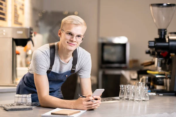 Happy Jonge Ober Met Pen Smartphone Stand Werkplek Voorkant Van — Stockfoto