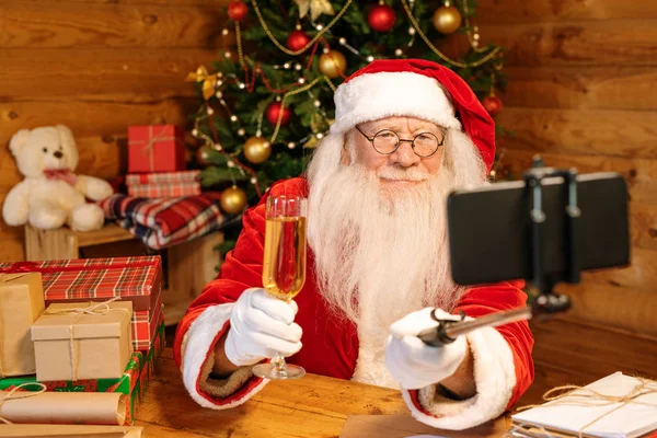 Современный Санта Клаус Струей Шампанского Делает Селфи Сидя Столом Канун — стоковое фото