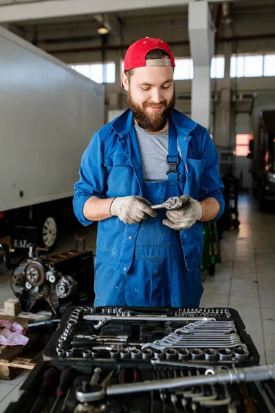 当代汽车维修服务的青年工人站在汽车电动机旁选择手工操作 — 图库照片