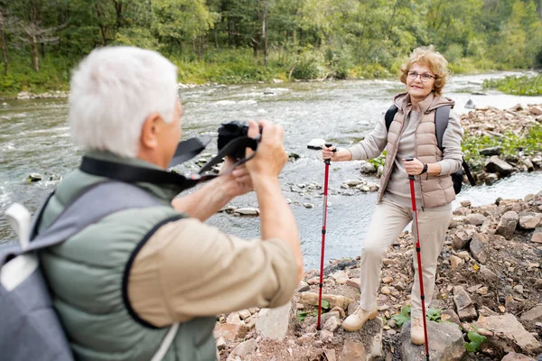 Volwassen Vrouw Met Trekking Sticks Rugzak Poseren Voor Camera Gehouden — Stockfoto