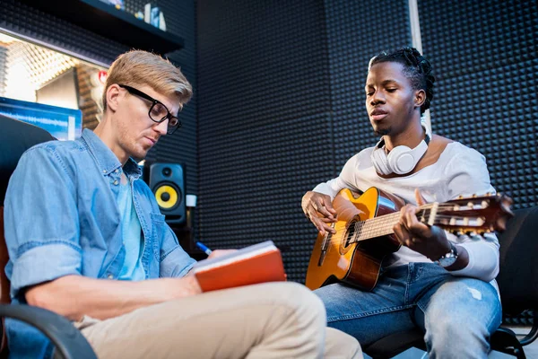 Genç Afrikalı Bir Adam Gitar Çalıp Şarkı Söylerken Meslektaşı Stüdyoda — Stok fotoğraf