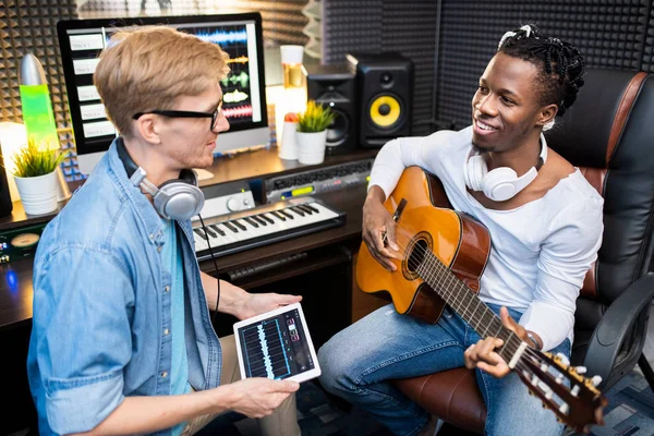 Dijital Tabletli Genç Adam Yerinde Ses Kayıt Stüdyosunda Otururken Gitarlı — Stok fotoğraf