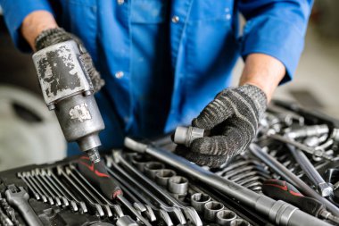 Uygun nozül seçilirken çalışma okulunu tutan çağdaş makine onarım servisinin eldiven mühendisi