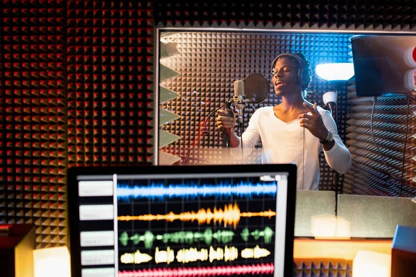 Młody Człowiek Pochodzenia Afrykańskiego Śpiewa Mikrofonie Studiu Nagraniowym Podczas Gdy — Zdjęcie stockowe