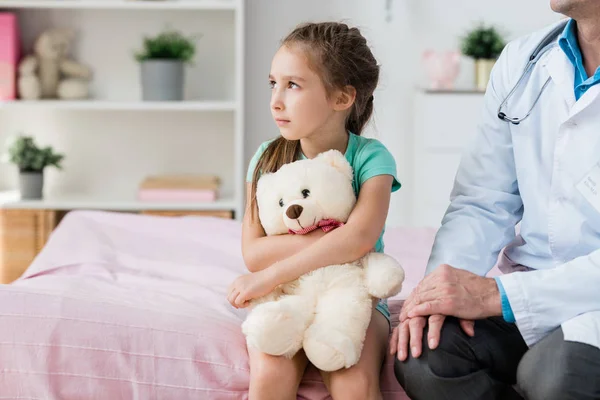 Niedliches Kleines Mädchen Mit Weißem Teddybär Das Durch Das Fenster — Stockfoto